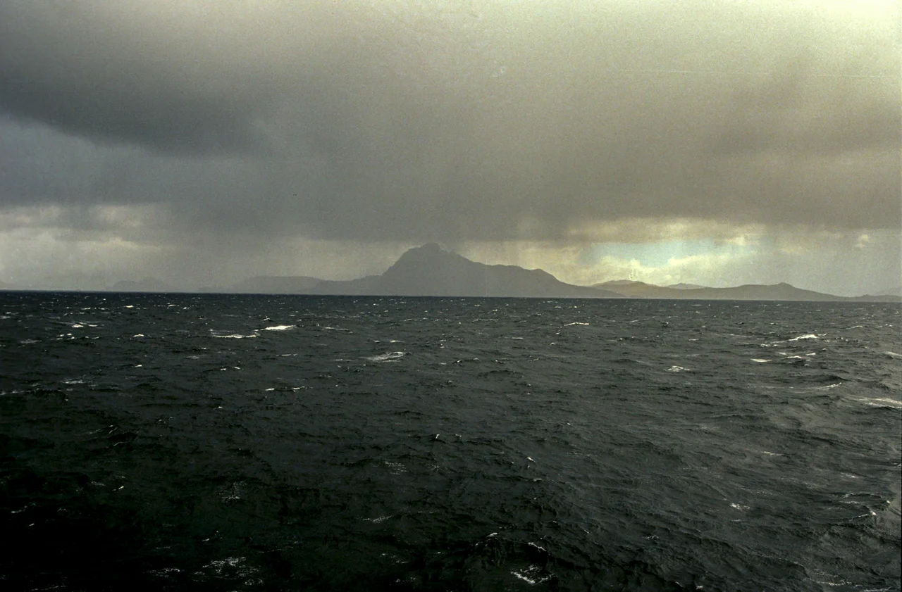 Cape Horn seen from the Chilean Station and Memorial location on 05/12/2006 at 08:00 AM. The small lighthouse can be seen as a white spot close to the seaside
