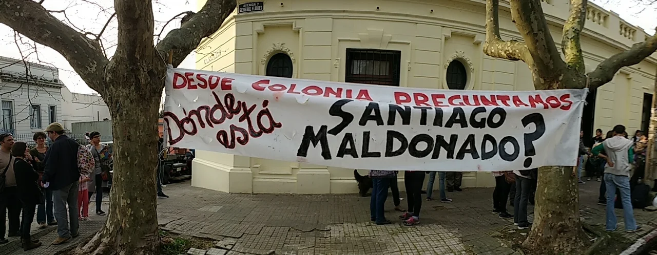 Manifestantes y cartel en frente del consulado argentino en Colonia del Sacramento: Dónde está Santiago Maldonado?