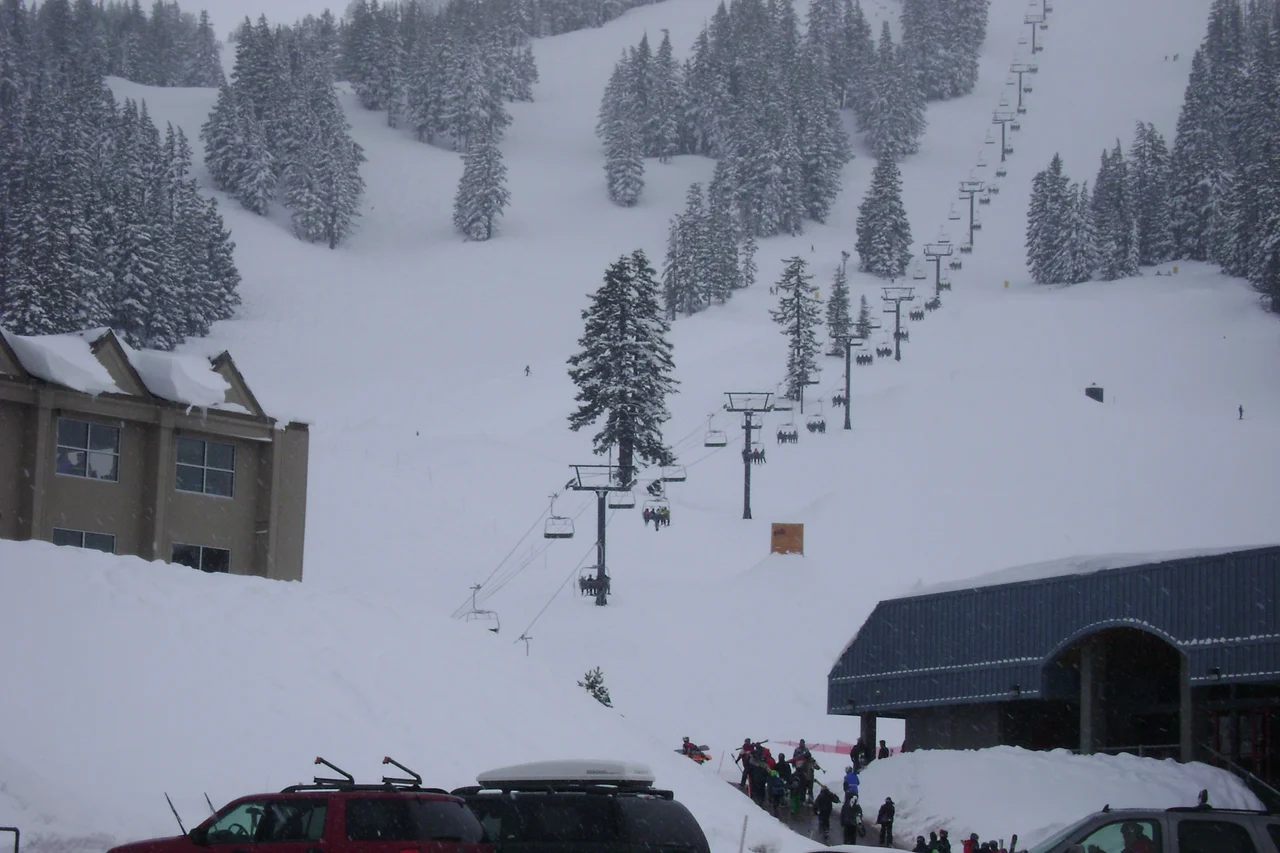 Pine Marten Express, a high-speed quad chairlift made by Doppelmayr CTEC at Mt. Bachelor Ski Area. On the left is the West Village Lodge, also called the main lodge. On the right is Bachelor Ski & Sport Shop, the largest retailer of it's kind in the pacific northwest. This photo was tooken from the parking lot.