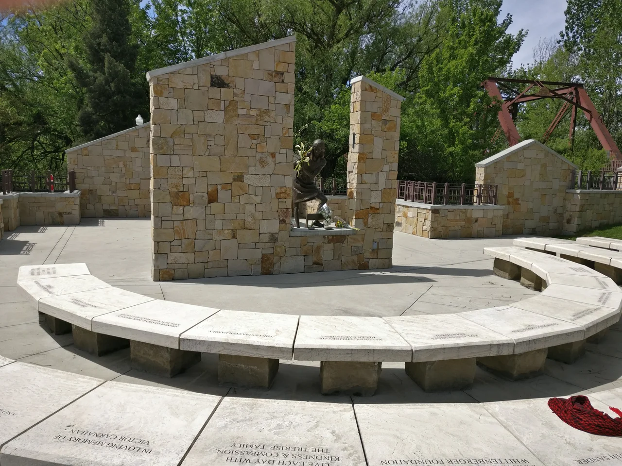The statue of Anne Frank at the Anne Frank Human Rights Memorial in Boise, Idaho from a medium distance; the Boise River is in the background.