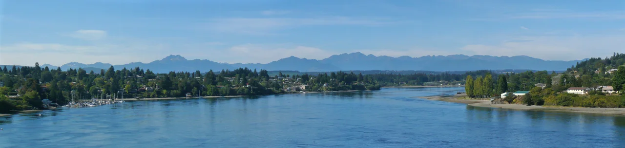 Aerial view of Bremerton, Washington, surrounded on three sides by water, out over Olympic Peninsula, facing northwest.