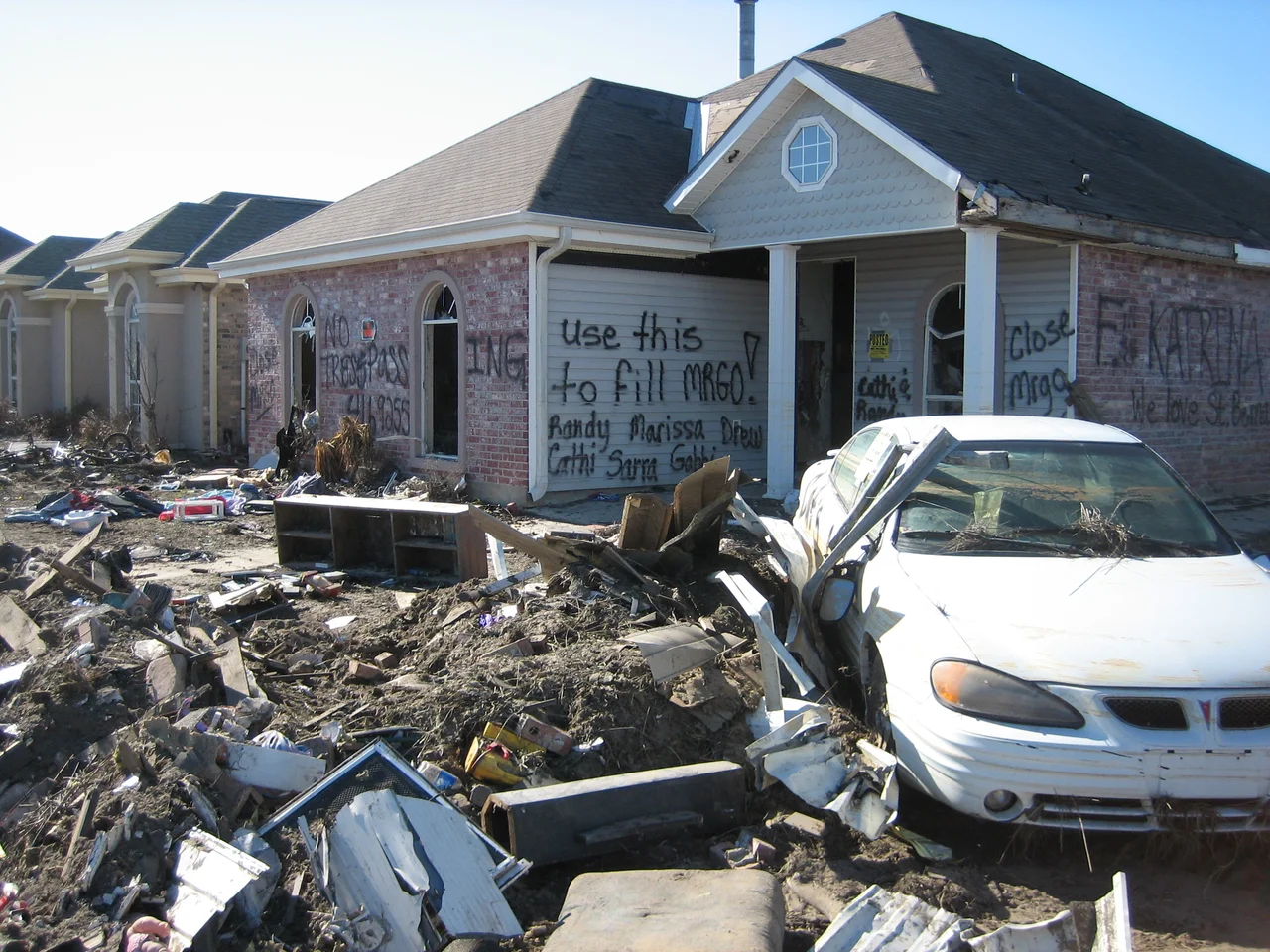 Hurricane Katrina aftermath in St. Bernard Parish, Louisiana:
House in Chalmette neighborhood devestated by storm surge from w:Mississippi River Gulf Outlet ("MRGO") has graffiti suggesting ruins be used to fill in the "MRGO".