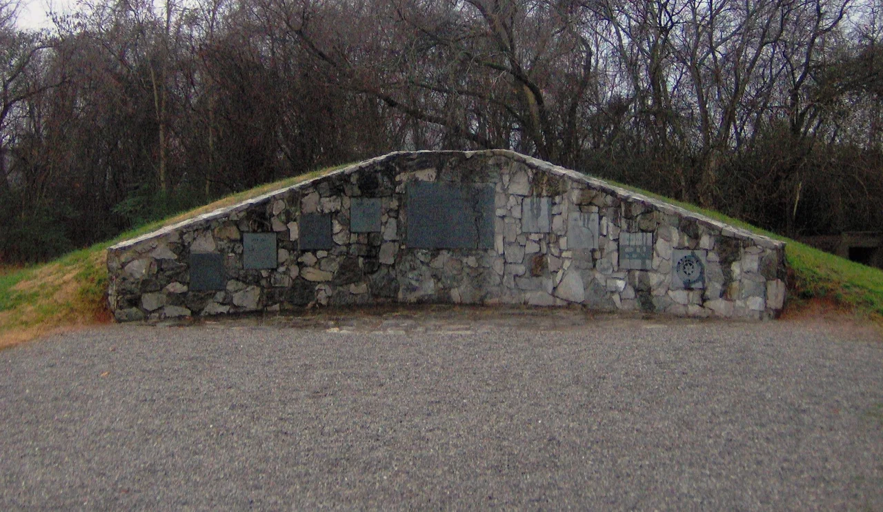 Burial mound at the Sequoyah Museum in Vonore, Tennessee, in the southeastern United States. The mound contains 191 burials that were excavated in the Tellico Archaeological Project, 1969-1979. The burials were reinterred here in the Spring of 1986. The right half of the center plaque displays Timberlake's "Draught of the Cherokee Country"; the left half reads:
A PRINCIPAL PEOPLE
IN MEMORY OF THE CHEROKEE PEOPLE
WHO LIVED IN THE LITTLE TENNESSEE
VALLEY PRIOR TO THE INUNDATION
OF THE TELLICO RESERVOIR IN 1979.
ARCHAEOLOGICAL INVESTIGATIONS
WERE CONDUCTED AT THE MAJOR
18TH CENTURY CHEROKEE SITES. THE
REMAINS OF 191 INDIVIDUALS
RECOVERED IN THOSE EXCAVATIONS
ARE BURIED IN THIS MOUND.