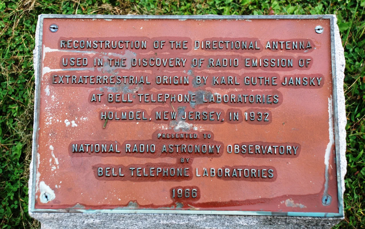 Plaque next to full-size replica of the first radio telescope, built by Karl Jansky and now at National Radio Astronomy Observatory in Green Bank, West Virginia. Text of the plaque: "Reconstruction of the directional antenna used in the discovery of Radio emission of extraterrestrial origin by Karl Guthe Jansky at Bell Telephone Laboratories Holmdel, New Jersy, in 1932. Presented to National Radio Astronomy Observatory by Bell Telephone Laboratories 1966".