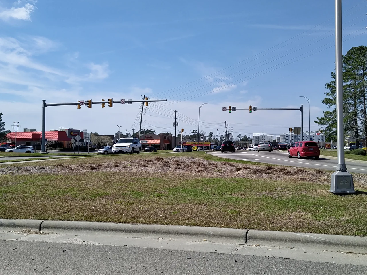 Village Road in the southeastern portion of Leland, North Carolina, showing the southern end of a major commercial strip, This was taken from the westbound off-ramp of US Routes 17, 74 and 76, where NC 133 departs those routes to head south towards the access routes to Oak Island and Southport. While not easily discernable from this view, this is a diverging diamond interchange.