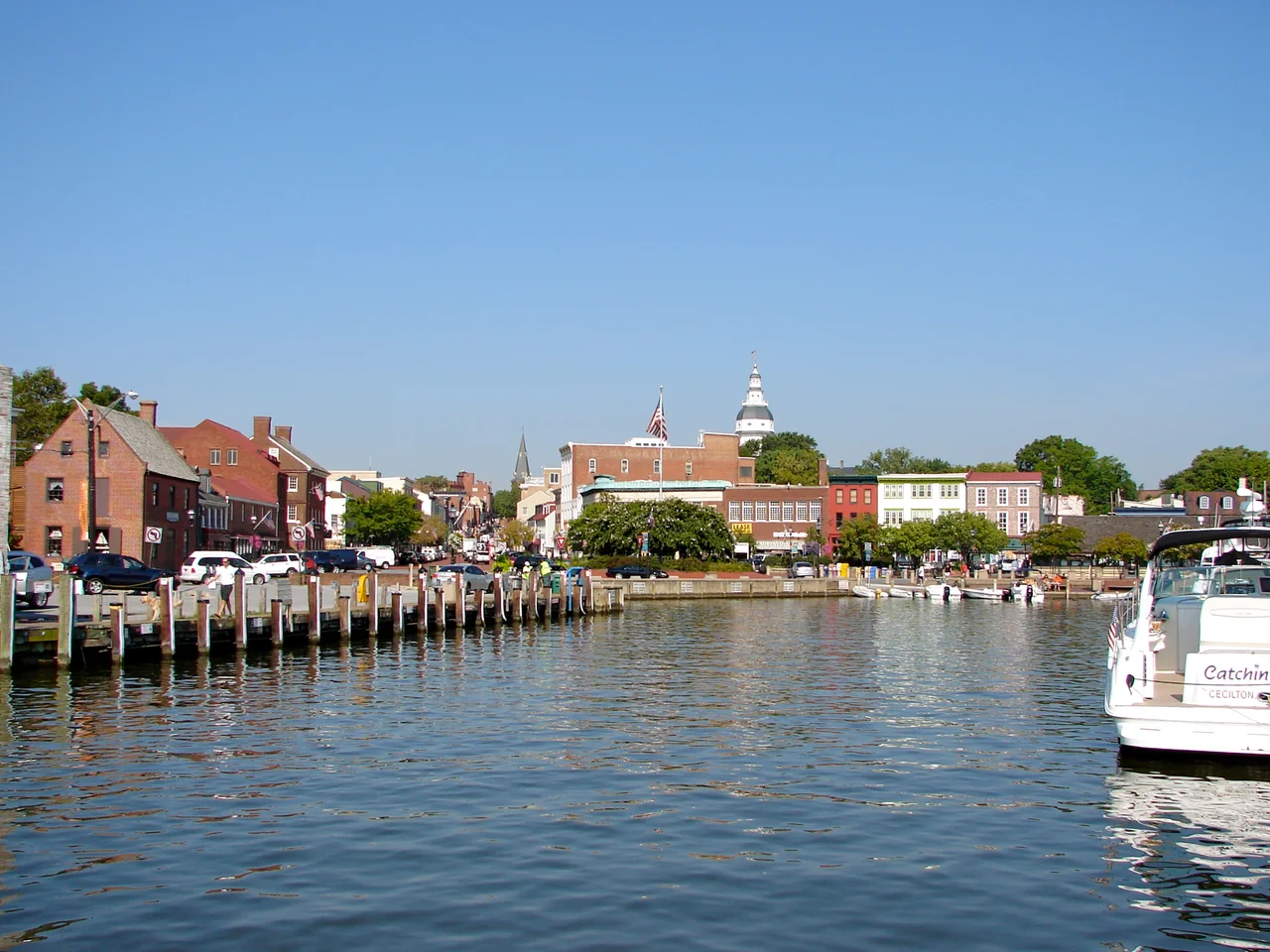 The dock or harbor in Annapolis, Maryland. Dock Street is just out of the frame of the photo to the right. Folks leaving their boats tied up here would step right out into the street. The Maryland State Capitol is the tall tower in the distance. At the end of the street/harbor is a set of statues showing Alex Haley (author) reading to children. His ancestor Kunte Kinte landed in the harbor as a slave coming from Africa, according to Haley (and historical markers near the statues).