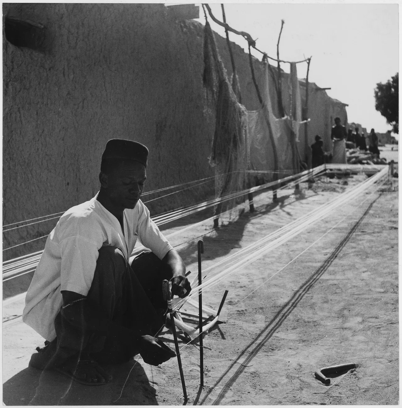 Africa. French West Africa. In the villiage of Niono, a native prepares thread - spun from locally-grown cotton - for... - NARA - 541638.tif
