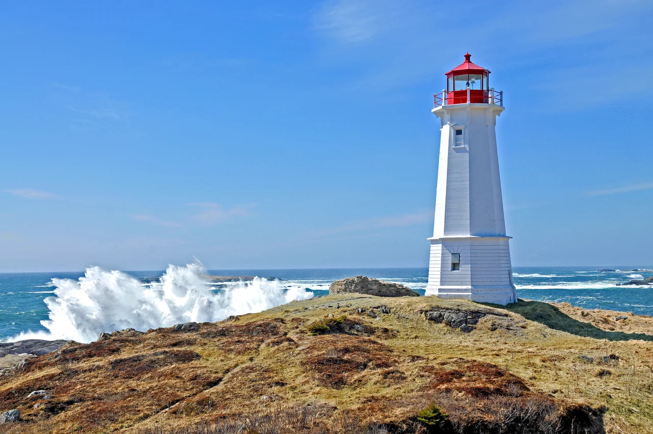 Louisbourg Lighthouse, 2008. This is the third light and was completed in 1923, a year after the second light burned. It is a white concrete octagonal tower, 55 feet high. Several modifications have been made to the characteristic of the light over time. Louisbourg, Nova Scotia, Canada
The lighthouse constructed by the French at Louisbourg was the first established in Canada, and the second on the North American continent. (The first North American light was lit on September 14, 1716 on Little Brewster Island in Boston Harbour.) Louisbourg, built near the northeast corner of Cape Breton Island, was the base from which the French planned to hold New France against the English. The Fortress was dependant upon ships from France to supply most of its needs. Safe entrance to the harbour at the end of the long voyage became a concern.
The initial plan to build a tower and light was made in late 1727, though the formal decision to build was not made until spring of 1729, after one of the King's ships, Le Profond nearly met its end in the harbour which was marked only by a navigational cross, and periodically by a bonfire.