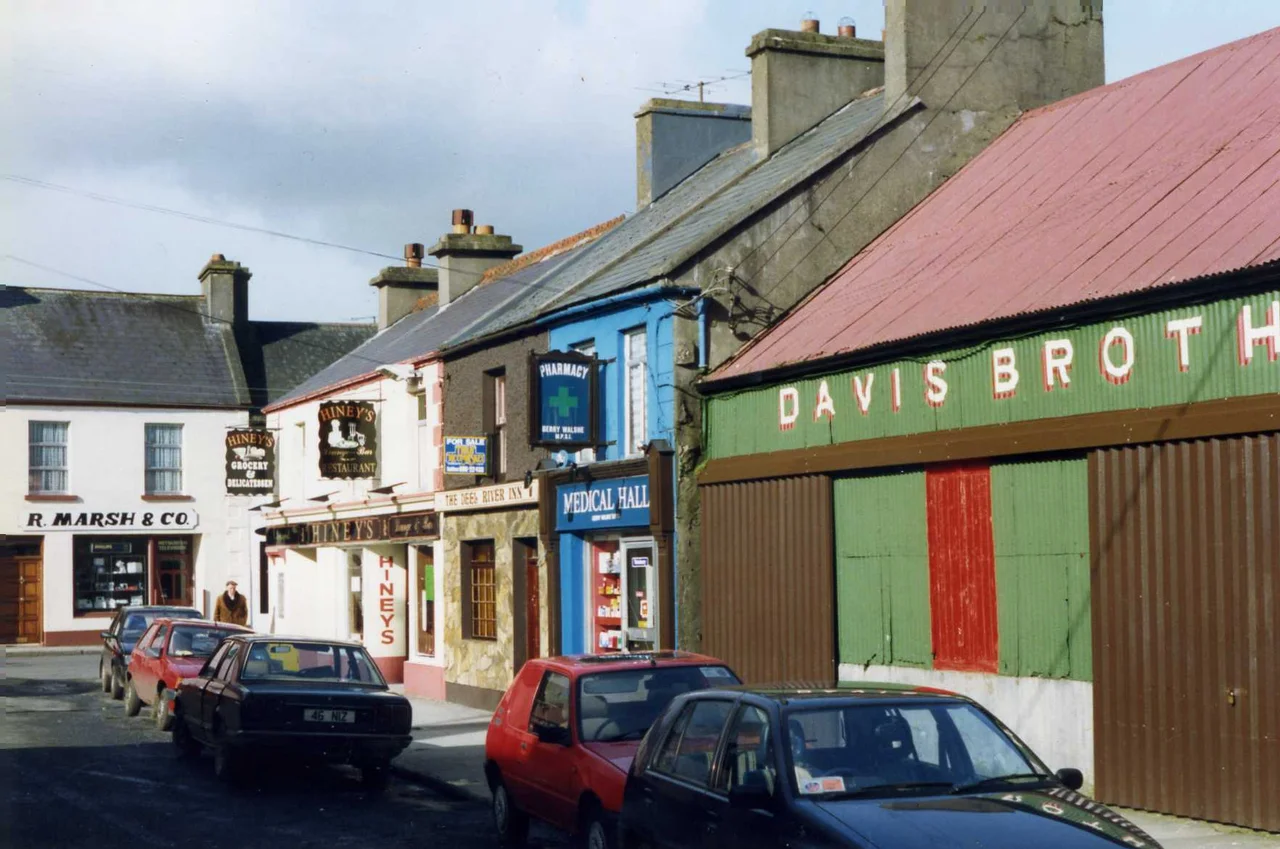 Crossmolina, featuring R.Marsh & Co. Hiney's Grocery Delicatessen and Restaurant, THe Deep River Inn, the Derry Walshe's Medical Hall and the nicely signwritten corrugated iron of Davis Brothers.