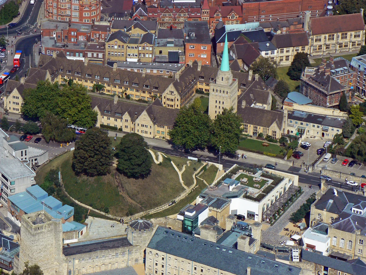 Aerial view showing Nuffield College, Oxford in the upper half of the photo and part of Oxford Castle on the lower half. Bottom left is D wing, with the square St George's Tower and round Debtors' Tower at either end. Between D wing and Nuffield College is the castle motte. Top left is part of St Peter's College.