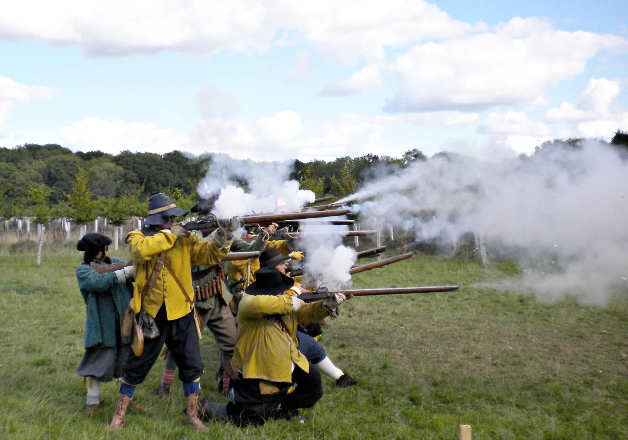 Musket volley by members of the Sealed Knot at Fernhurst Furnace, West Sussex, England.