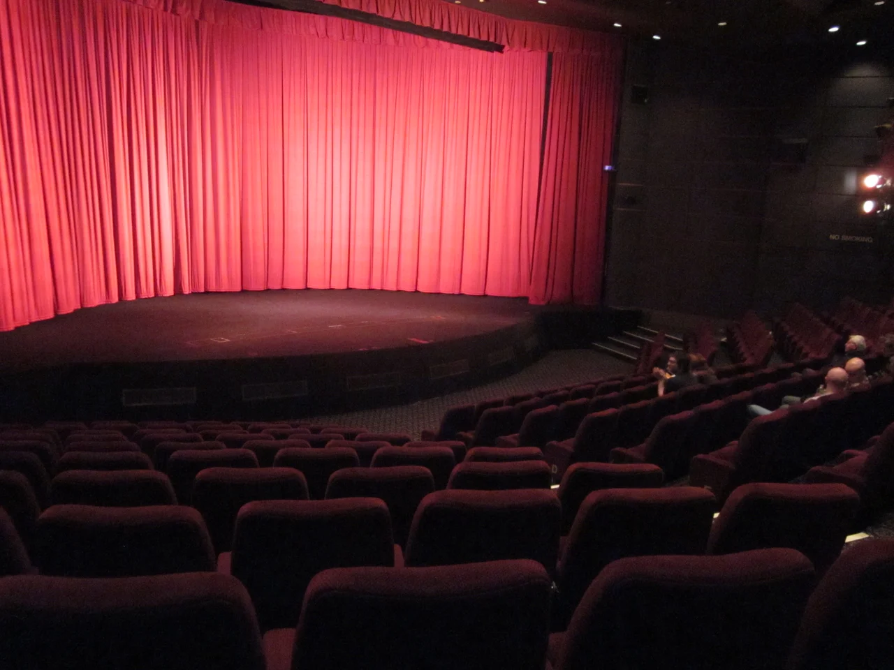 Interior of the Pictureville Cinema, Bradford, part of the National Media Museum. The curtains cover a curved screen ready to show a Cinerama film. A flat screen can be lowered from the top (just visible below the pelmet) for other films.