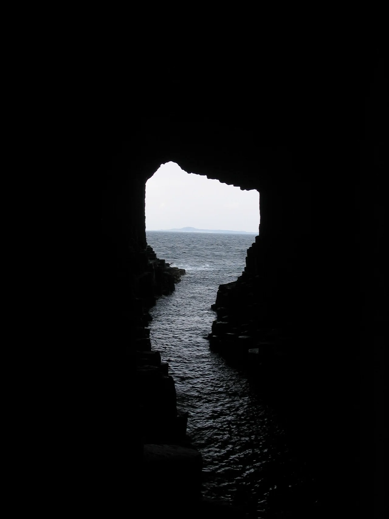 Internal view of Fingal's Cave on the island of Staffa, with a view across the open sea to the island of Iona, both are islands of the Inner Hebrides in Argyll and Bute, Scotland. Photo taken May 2008.