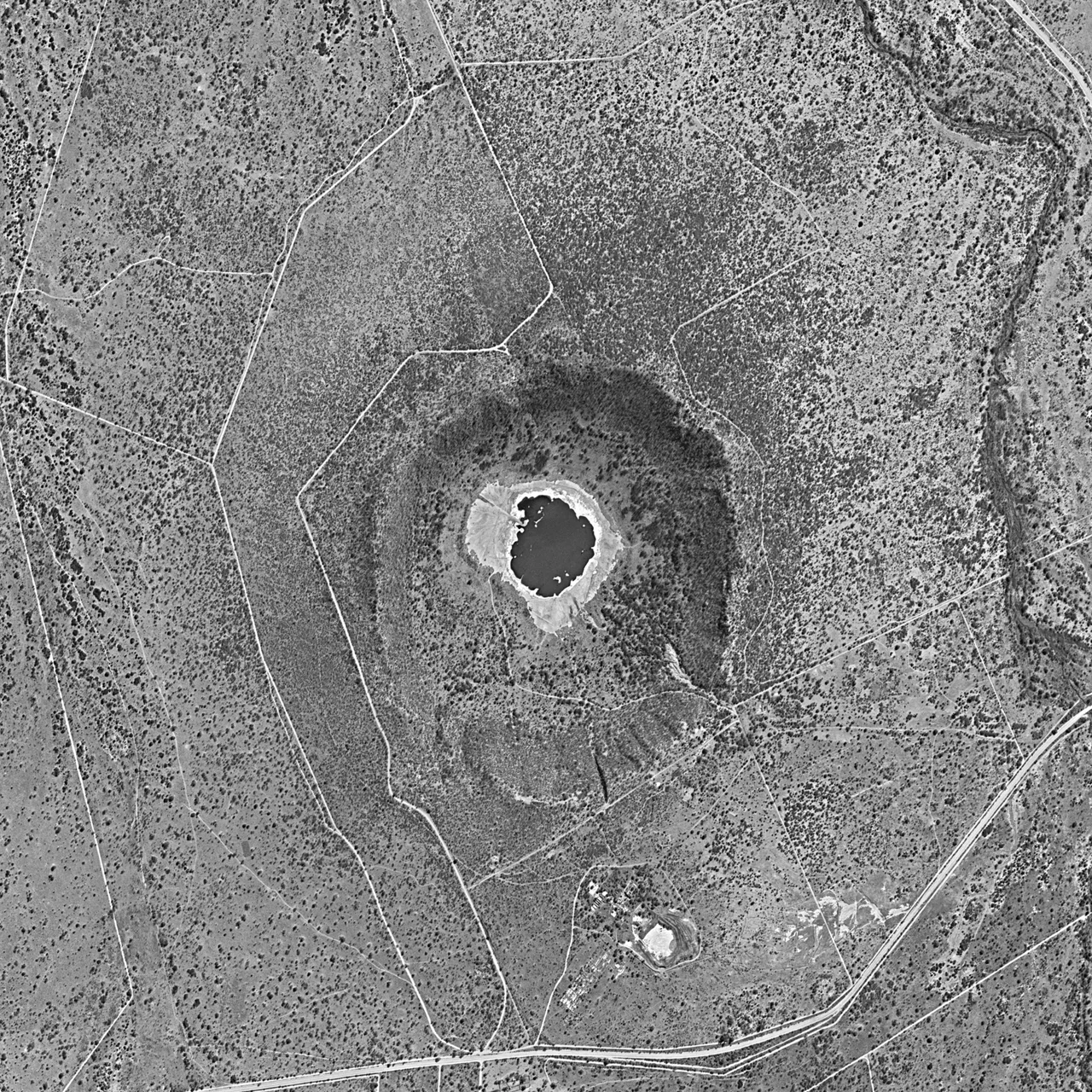Tswaing crater, within Tswaing Nature Reserve, north of Johannesburg, South Africa, in 1984. Approximate north at top. The creek at right is called Soutpanspruit. D3C1219-200530F026 is the panoramic camera photo number. This is cropped from a much larger full image. Image width is about 3.04 km.