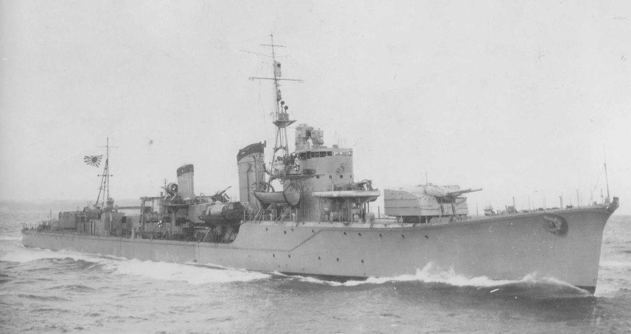 The Japanese destroyer Harusame, photographed through the periscope ot the U.S. Navy submarine USS Wahoo (SS-238) after she had been torpedoed by the submarine near Wewak, New Guinea, on 24 January 1943. Harusame's back is clearly broken, but she was repaired and returned to service despite this heavy damage.
Wartime intelligence evaluated this photo as showing one of the Asashio-class (see Photographic Intelligence Report # 82, 17 March 1943). However, the ship's bridge structure identifies her as a Shiratsuyu-class destroyer, with the # 2 (single) 5 gun mount removed.
