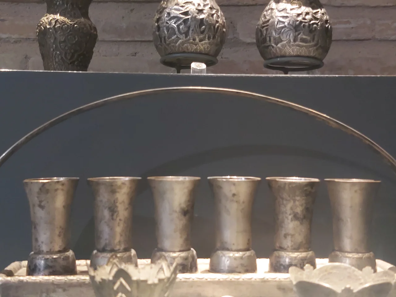 بئر زمزم الأثري (Historic Zamzam well mouthpiece), description reads: (line 1) The mouthpiece of the well of Zamzam. (line 2) The pulley for lifting Zamzam water dating back to the end of the fourteenth century of Hijrah. (line 3) The brass bucket which was used to be in the well of Zamzam dating back to 1299 Hijrah.