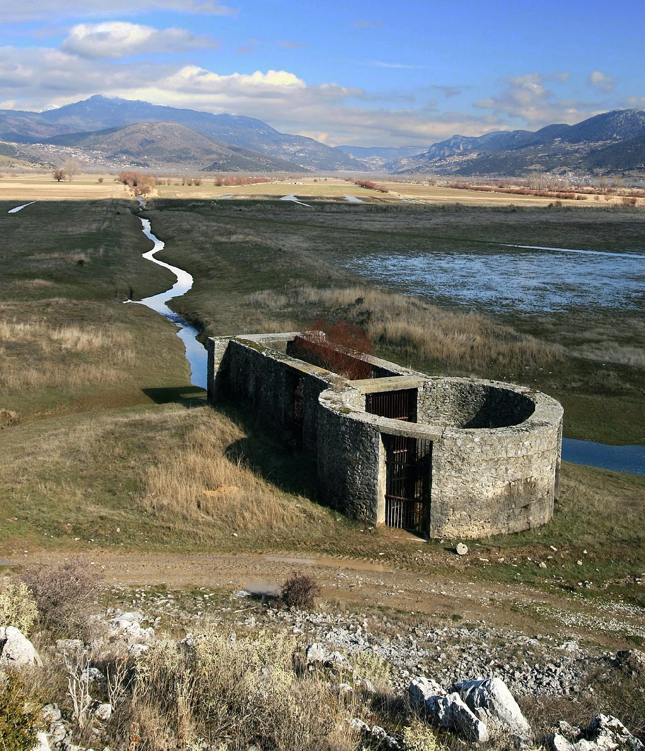 One of 3 Ponors in the southern part of the polje Feneos, Corinthia, Peloponnese.
When precipitation of winters is exceptionally rich, parts of the polje become flooded even nowadays; until the second half of the 19th century there was even an almost permanent lake. Marks of the watertable at the bottom of the slopes are still visible. Construction of a system of draining ditches reduced floods.
By hydrogeological tracertests in 1984 subsurface drainage through the surrounding limestone mountains emerged in a karst spring of river Ladonas, 15 km south east.