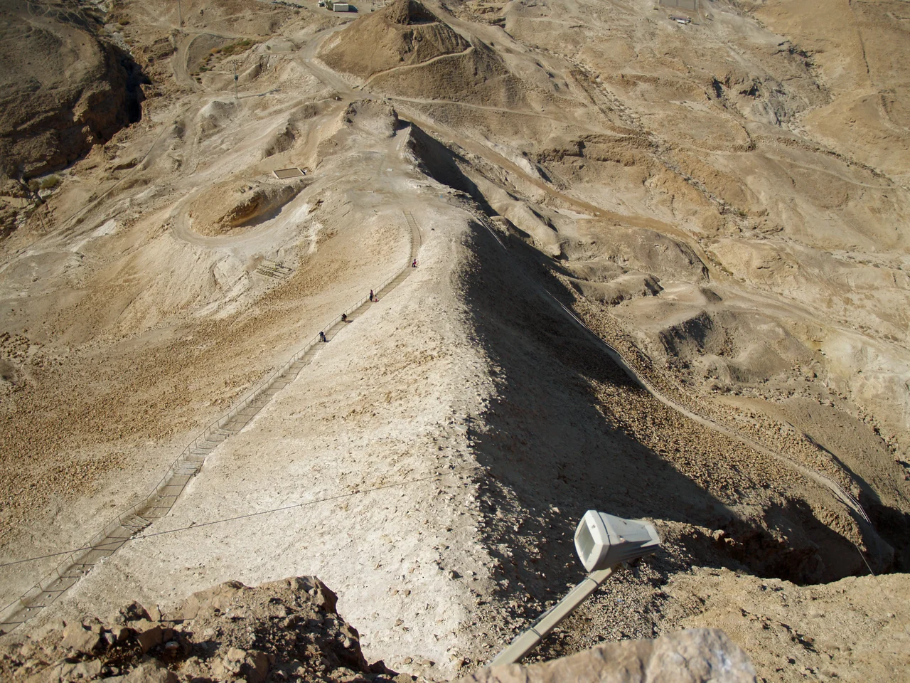 Aerial view of Masada (Hebrew מצדה), in the Judaean Desert (Hebrew: מִדְבַּר יְהוּדָה, Arabic: صحراء يهودا), with the Dead Sea in the distance.