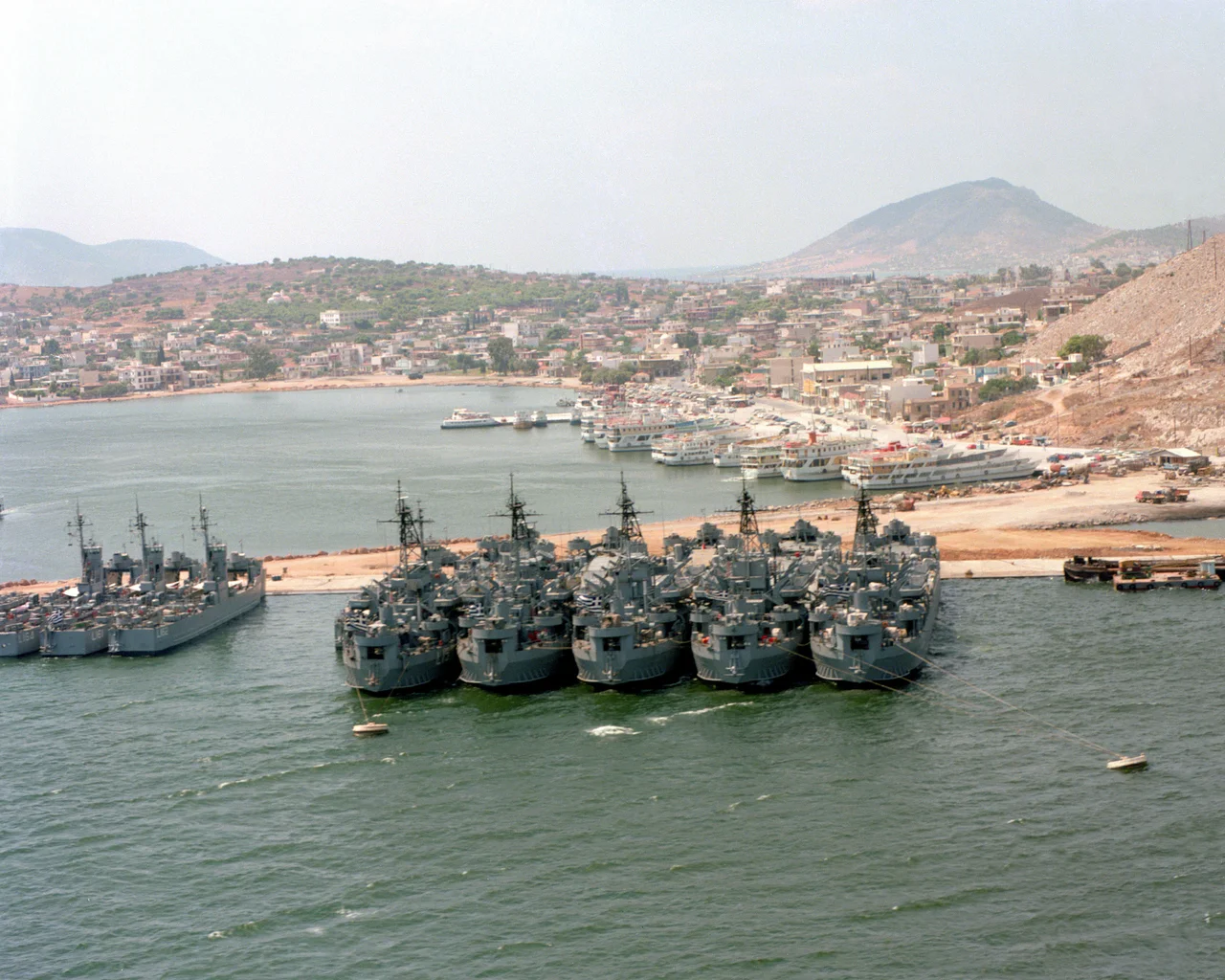 View of the Greek Salamis Naval Base in 1979. Visible the five former U.S. Navy tank landing ships, Ikaria (ex LST-1086), Kriti (LST-1076), Lesbos (LST-389), Rhodos (LST-391), Syros (LST-325), and three LSMs.