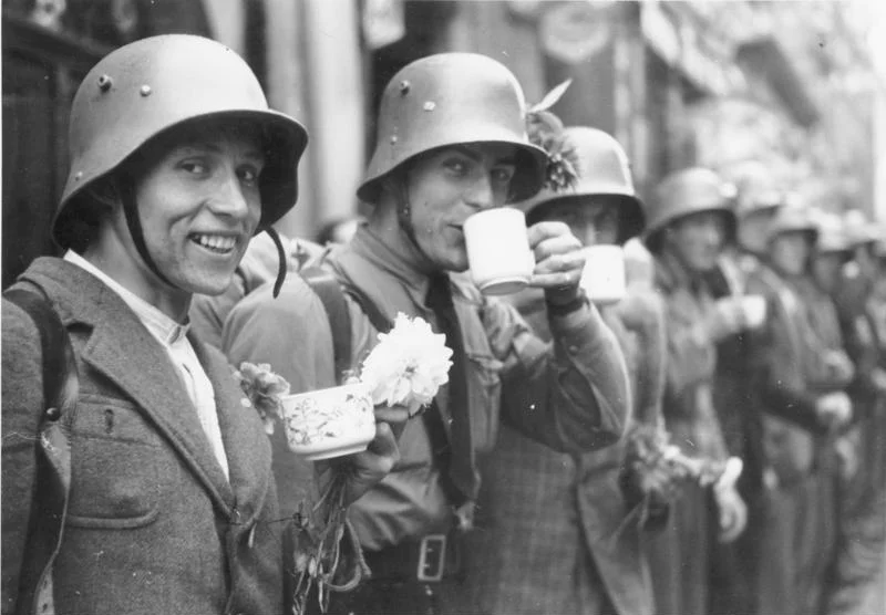 For documentary purposes the German Federal Archive often retained the original image captions, which may be erroneous, biased, obsolete or politically extreme. Einmarsch in das Sudetenland. Die Männer des sudetendeutschen Freikorps bekommen von der Bevölkerung Erfrischungen.
Members of the Sudeten-German Voluntary Corps are served refreshments by the population.
3.10.1938
9.00 Uhr
Eger. Sudetenland
