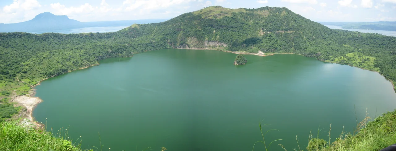Taal Lake is a freshwater lake in the province of Batangas, on the island of Luzon, Philippines. The lake is situated within a caldera formed by very large eruptions between 500,000 and 100,000 years ago. The active Taal Volcano, which is the one responsible for the lake's sulfuric content, lies on an island in the center of the lake, called Volcano Island. In addition, there is a crater lake on Volcano Island, which is in Lake Taal, which in turn is on Luzon (an island). That crater lake is the world's largest lake on an island in a lake on an island. The small island on the far side of the lake is called Vulcan Point.